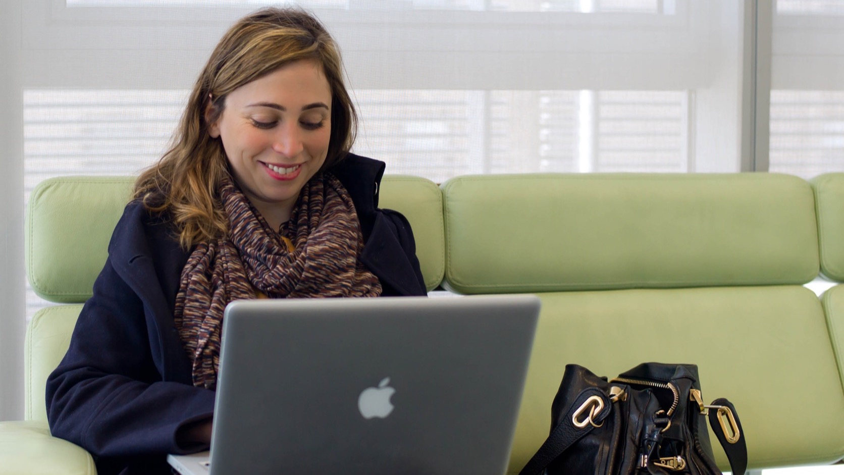 Current AI CEO Ayah Bdeir working on a laptop.