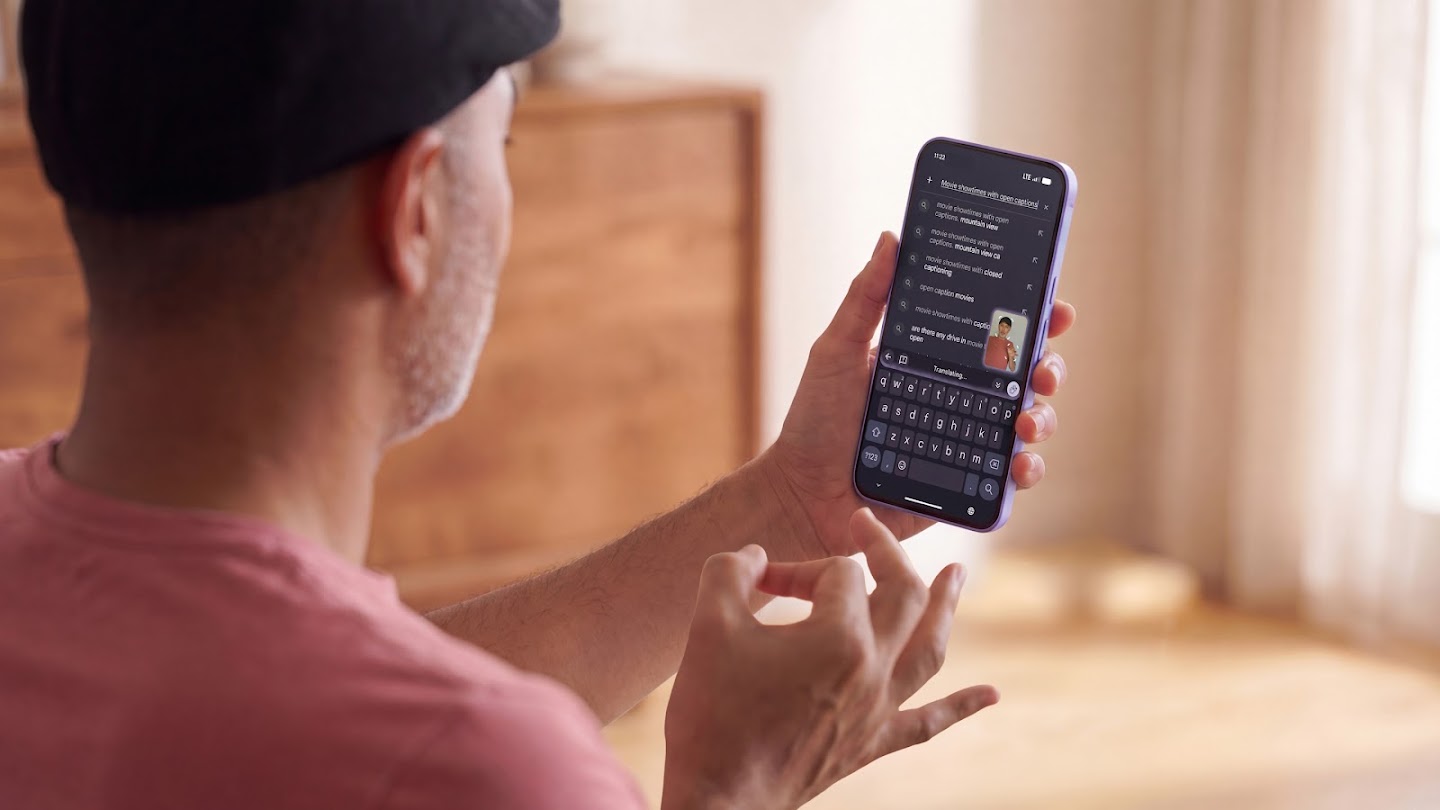 A person signs with one hand while holding a smartphone to use Gboard sign-to-text dictation.