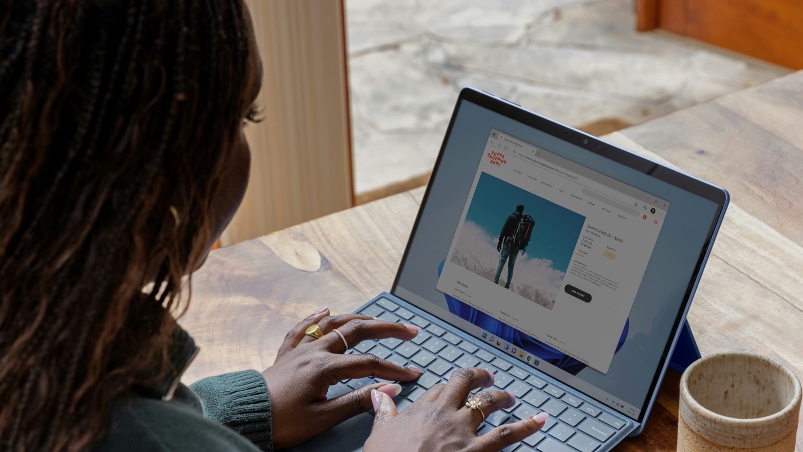 A woman compares products on a laptop at a table, illustrating the shopping decisions that ChatGPT advertisers want to reach.